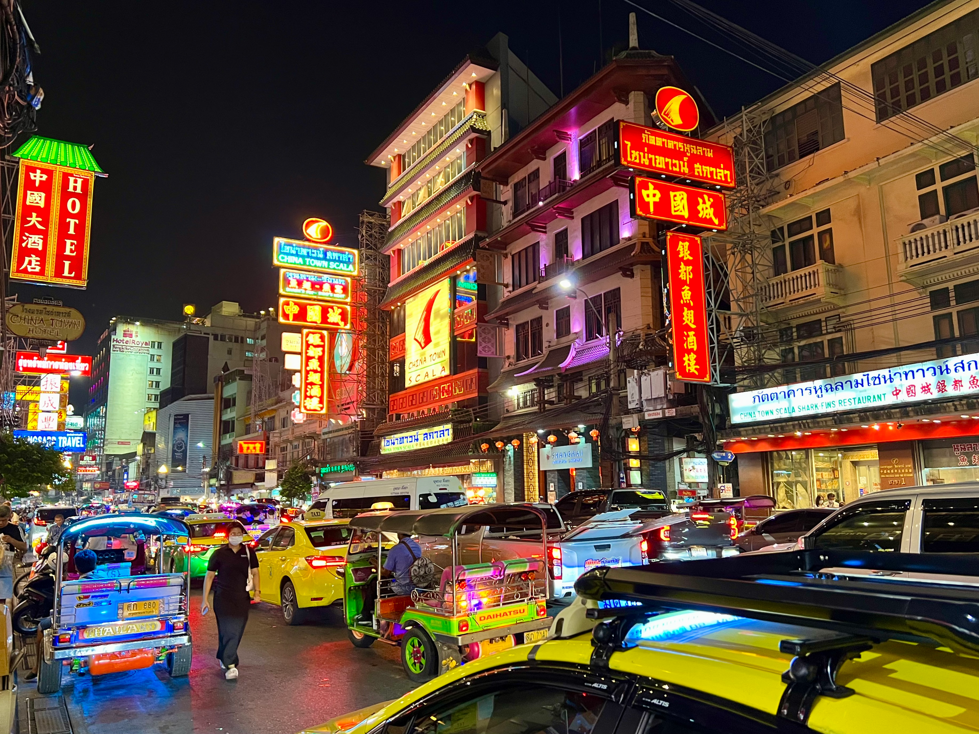 Busy street in chinatown, Bangkok, Thailand. Tuk tuk, yellow taxis, cars and neon lights