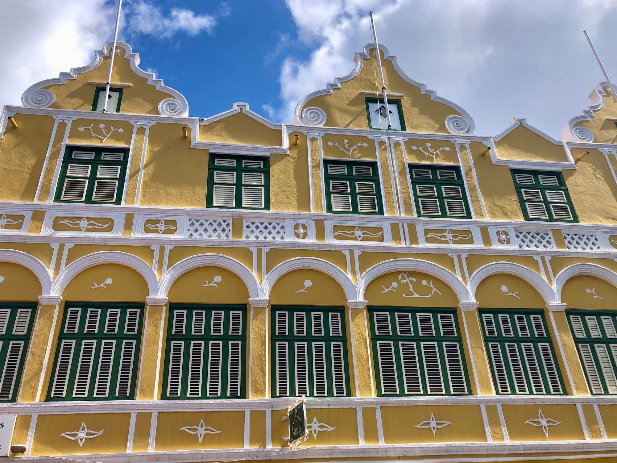 Yellow building with white and dark green decoration in Punda, Willemstad, Curaçao