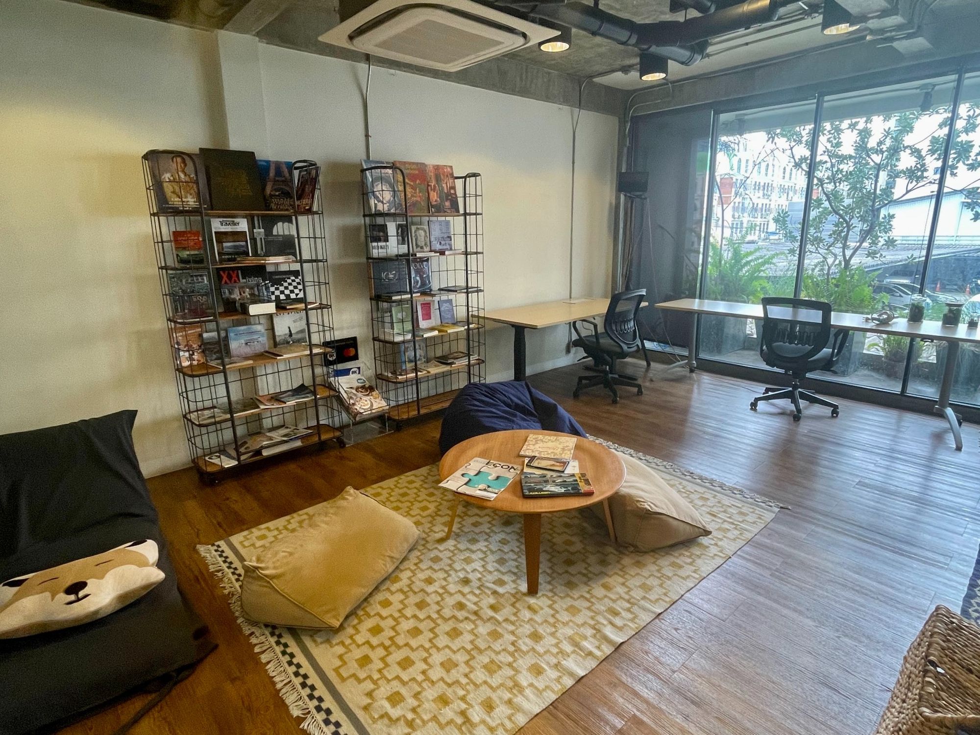 econd floor of Wolf Coworking space, Thailand. There’s lots of desk space in an open-plan format with a chill-out area with books, bean bags and a whiteboard 