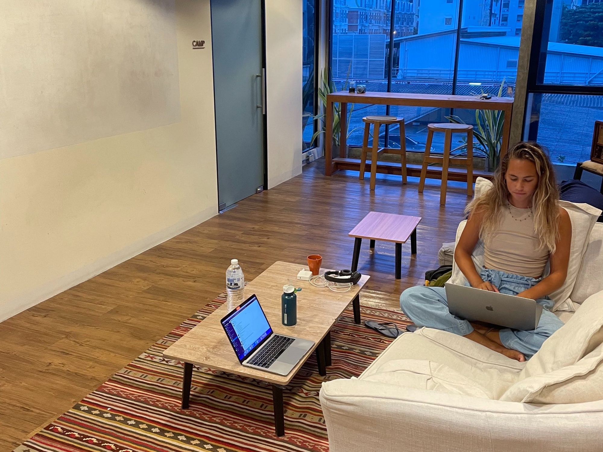 Third floor, Wolf Coworking Space, Bangkok, Thailand. A couch and a table with two high chairs.