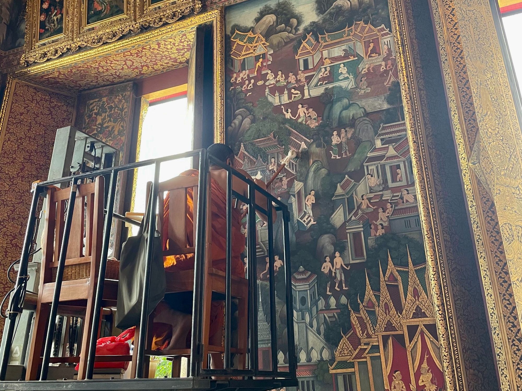 A buddhist monk painting the wall in Wat Pho Temple, Bangkok.