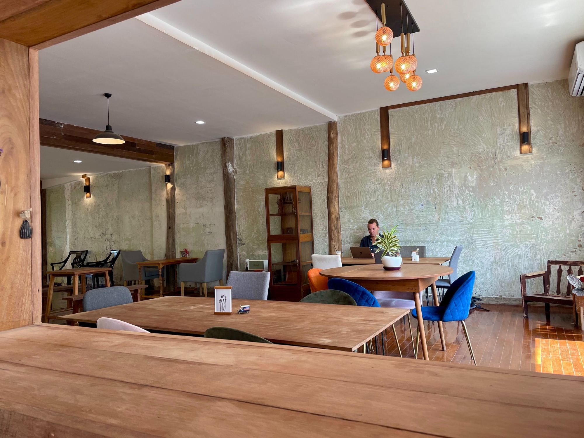 Izaac working on his laptop from the story 106 co-working space & café, spacious room with chairs