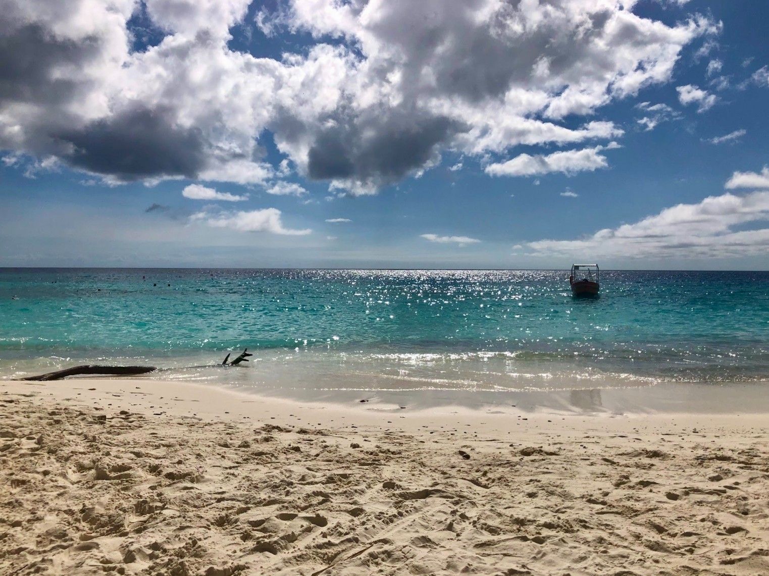 Playa Cas Abao, Valentijnsbaai, white beach, ocean, small boat, blue sky with white clouds, Curaçao