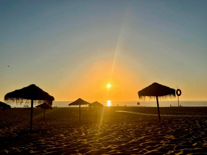 Sunset on the beach, sand, umbrellas in Portugal