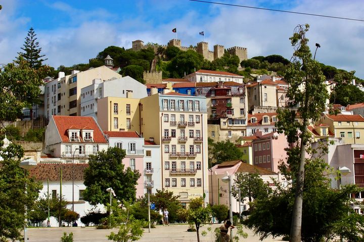 Yellow, pink, white buildings, Castelo de S. Jorge on the hill, Lisbon, Portugal